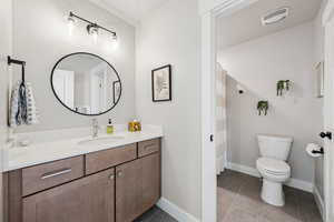 Full bathroom featuring a shower with shower curtain, vanity, and dark tile patterned floors
