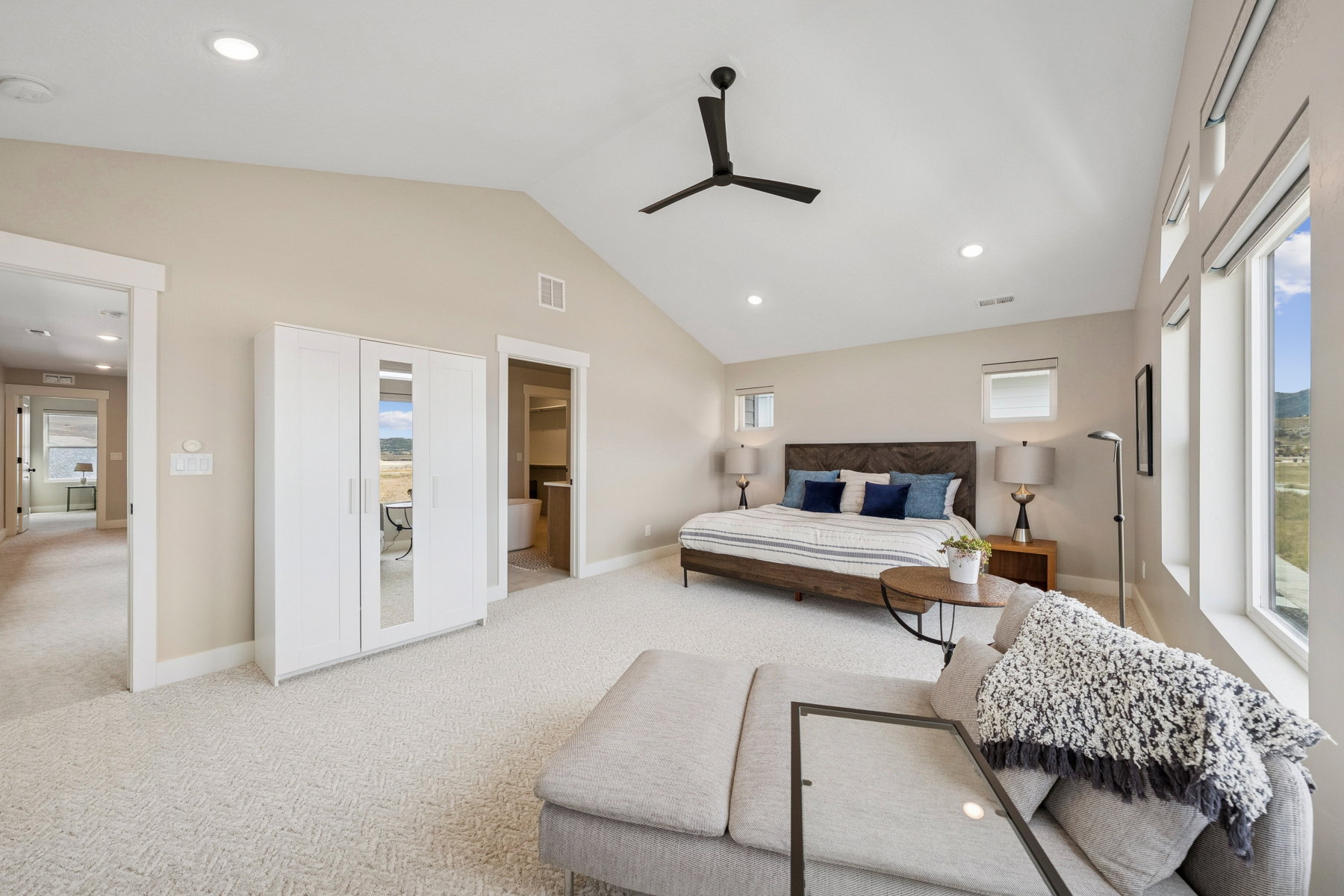 Bedroom with recessed lighting, ensuite bath, light colored carpet, vaulted ceiling, and a ceiling fan