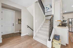 Stairs featuring recessed lighting and wood finished floors
