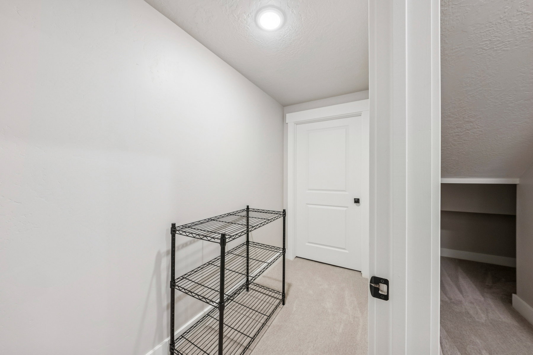 Hall with a textured ceiling and light colored carpet