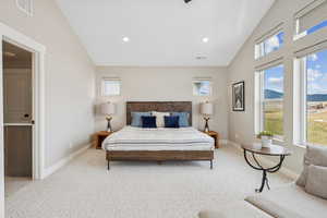 Bedroom with vaulted ceiling, light carpet, a mountain view, and recessed lighting