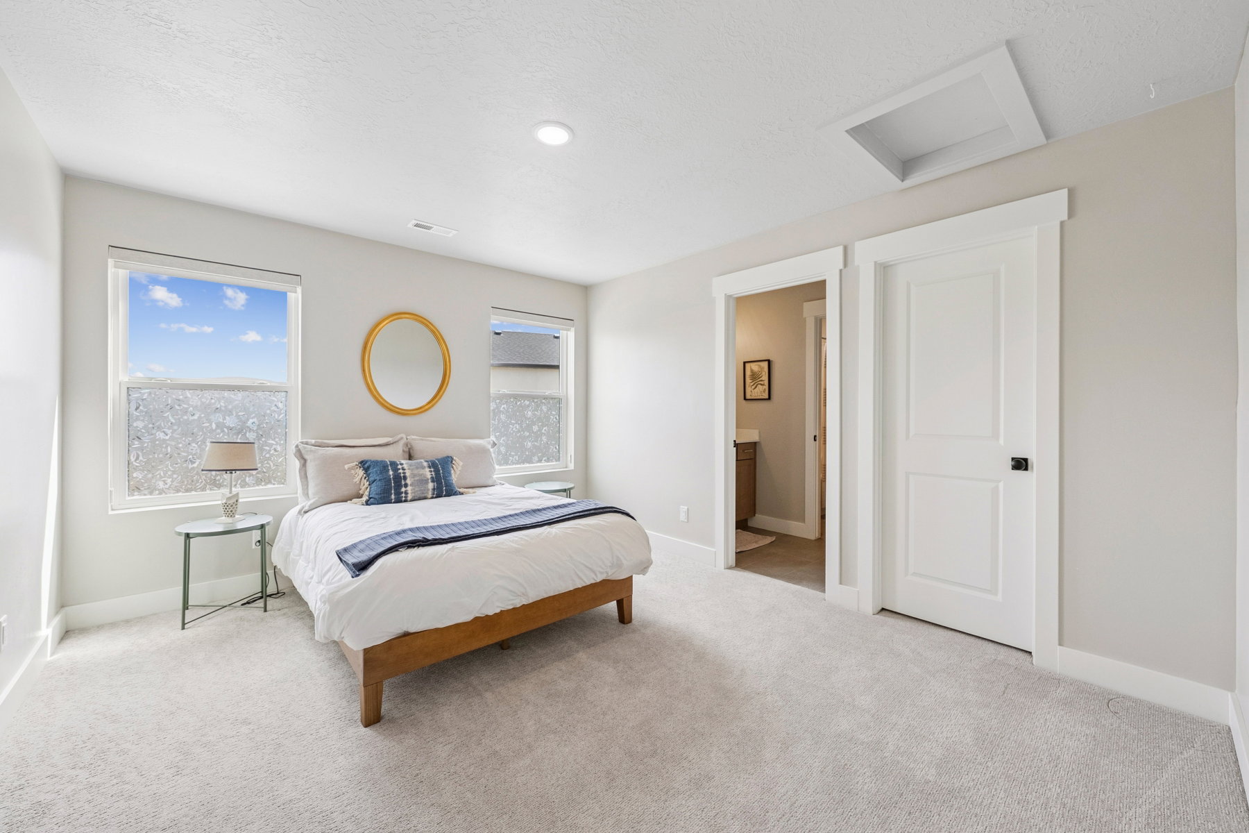 Bedroom with light carpet, connected bathroom, and a textured ceiling