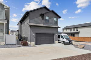 View of side of home featuring concrete driveway and a garage