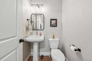 Bathroom with toilet and wood finished floors