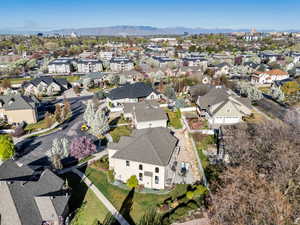 Aerial view of property and surrounding area featuring nearby suburban area and mountains