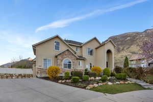 Traditional-style home with stucco siding, stone siding, and a mountain view