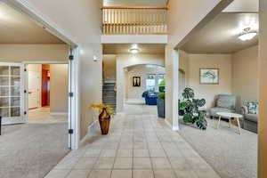 Tiled entryway with sitting areas on each side of foyer