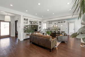 Living area featuring built in features, dark wood-type flooring, and recessed lighting