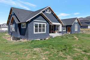 Craftsman-style house featuring a front yard, roof with shingles, and covered porch