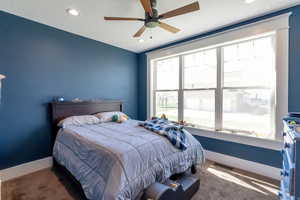 Bedroom with dark colored carpet, a ceiling fan, and recessed lighting