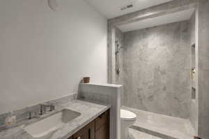 Full bathroom with vanity and a marble finish shower