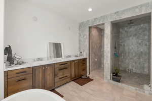 Bathroom featuring vanity, a tile shower, a soaking tub, and recessed lighting