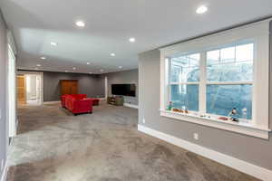 Living area with recessed lighting and light colored carpet