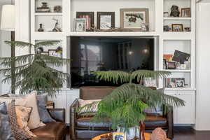 Living area with built in shelves and wood finished floors