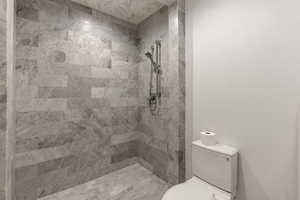 Bathroom with toilet and tiled shower
