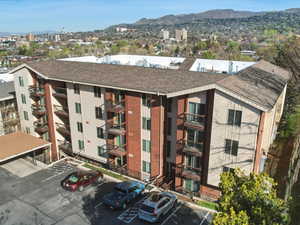 View of apartment building / complex featuring a mountain view and uncovered parking