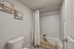 Bathroom featuring toilet and shower / bath combo