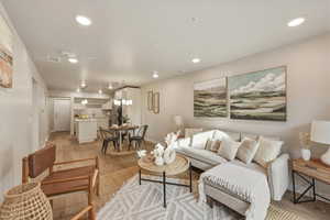 Living room with light wood-type flooring and recessed lighting