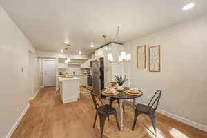 Dining area featuring light wood-type flooring and suspended lighting