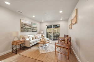 Living area with light wood-style floors and recessed lighting