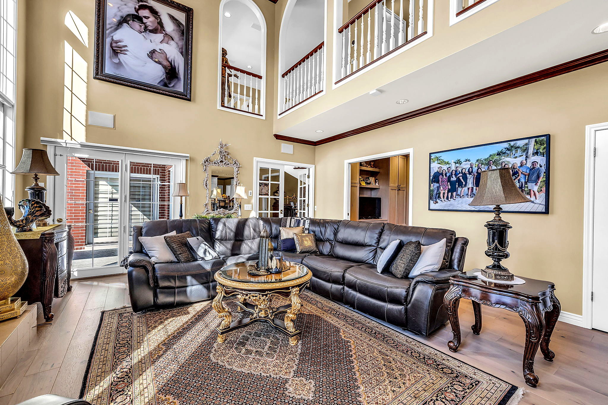 Living area featuring hardwood / wood-style flooring, a high ceiling, and ornamental molding
