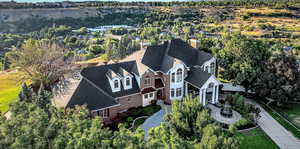 Aerial view of property and surrounding area featuring a tree filled landscape