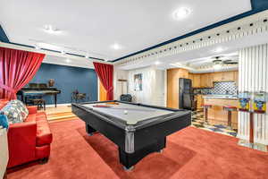 Game room with crown molding, billiards, track lighting, ceiling fan, and light colored carpet