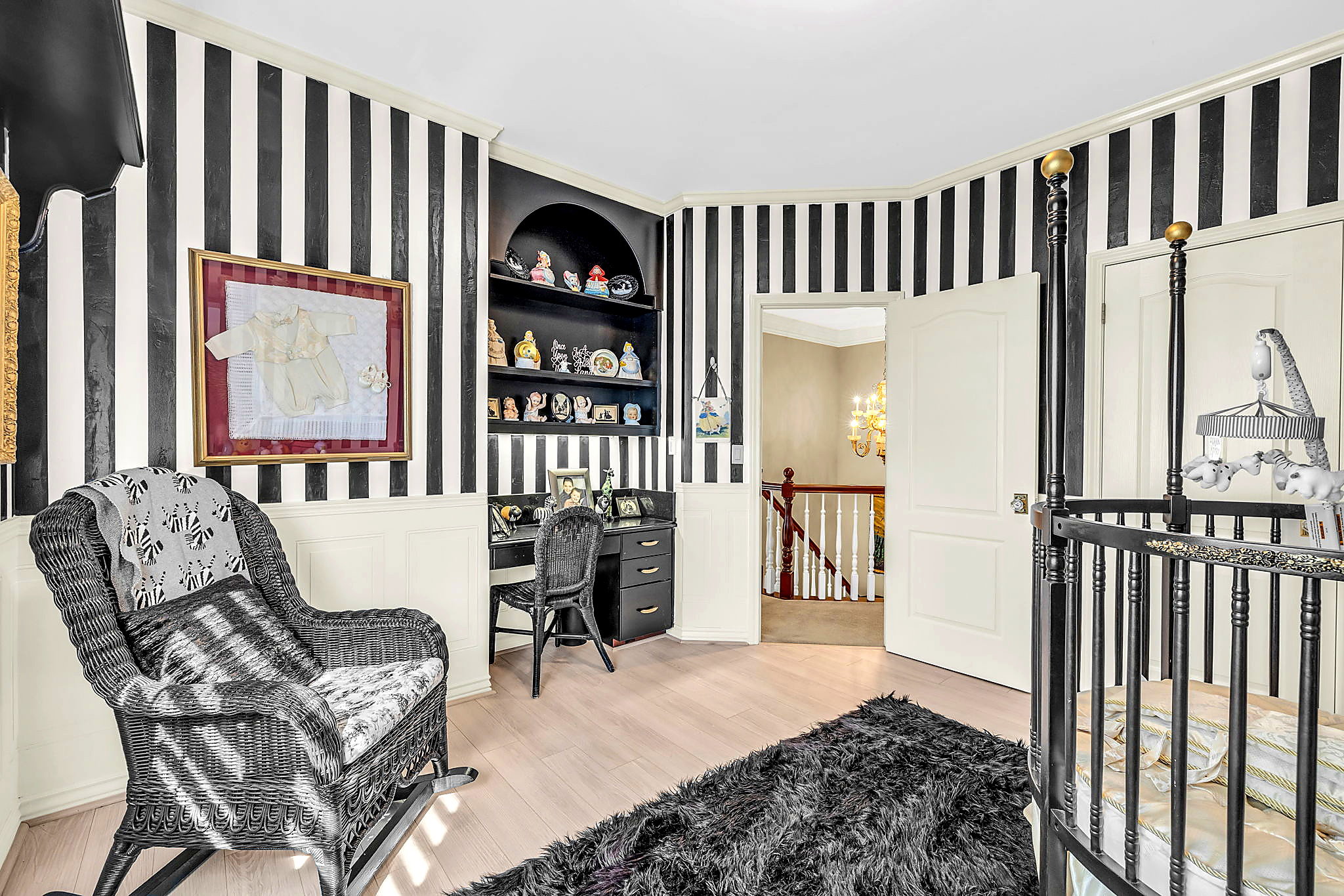 Bedroom featuring wainscoting, built in study area, wallpapered walls, light wood-style floors, and hanging lights