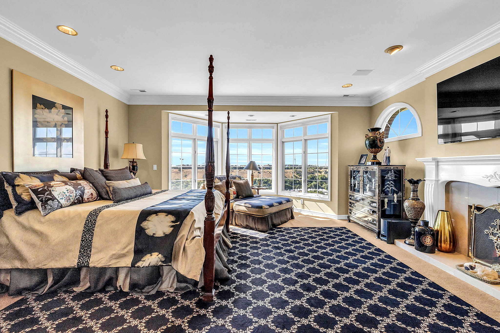 Bedroom with a fireplace, light carpet, ornamental molding, multiple windows, and access to outside