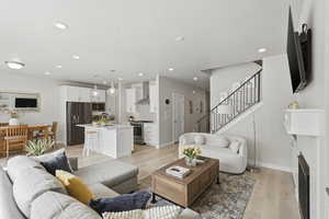 Living area featuring light wood finished floors, a fireplace, recessed lighting, and a textured ceiling