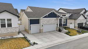 View of front facade featuring stone siding, a gate, and board and batten siding