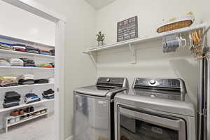 Laundry room featuring washer and clothes dryer and light carpet