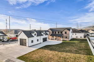 Modern farmhouse style home with a residential view, driveway, a front yard, and a garage