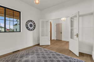 Unfurnished bedroom featuring french doors and light wood finished floors