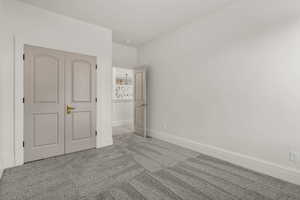 Unfurnished bedroom featuring light colored carpet and a closet