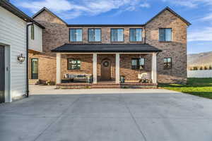 View of front of property with covered porch and brick siding