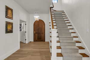 Foyer with stairs and light wood-style floors