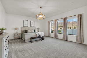 Bedroom with light colored carpet, a mountain view, and a chandelier