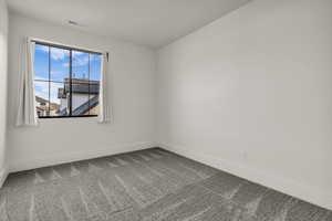 Spare room with light carpet and baseboards