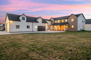 View of front of house with a front yard, brick siding, and driveway
