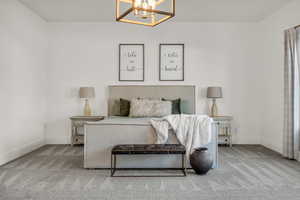 Carpeted bedroom featuring hanging lights and baseboards
