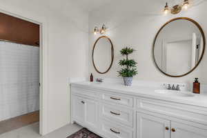 Full bathroom with double vanity and curtained shower