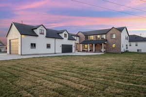 View of front facade featuring a yard, brick siding, and driveway
