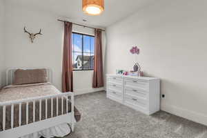Bedroom with light carpet and baseboards