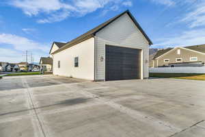 View of side of home featuring a residential view, driveway, and a garage