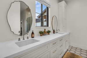 Full bathroom featuring double vanity and a shower stall