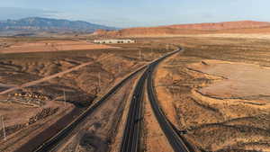 View of dirt / gravel road with a view of countryside, a mountain view, and view of desert landscape