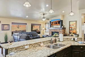 Kitchen with light stone countertops, open floor plan, and lofted ceiling