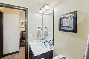 Half bath with vanity and a textured wall