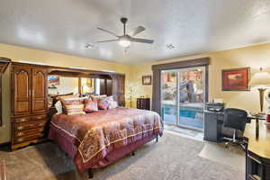 Bedroom with a textured ceiling, access to outside, light carpet, an office area, and a ceiling fan